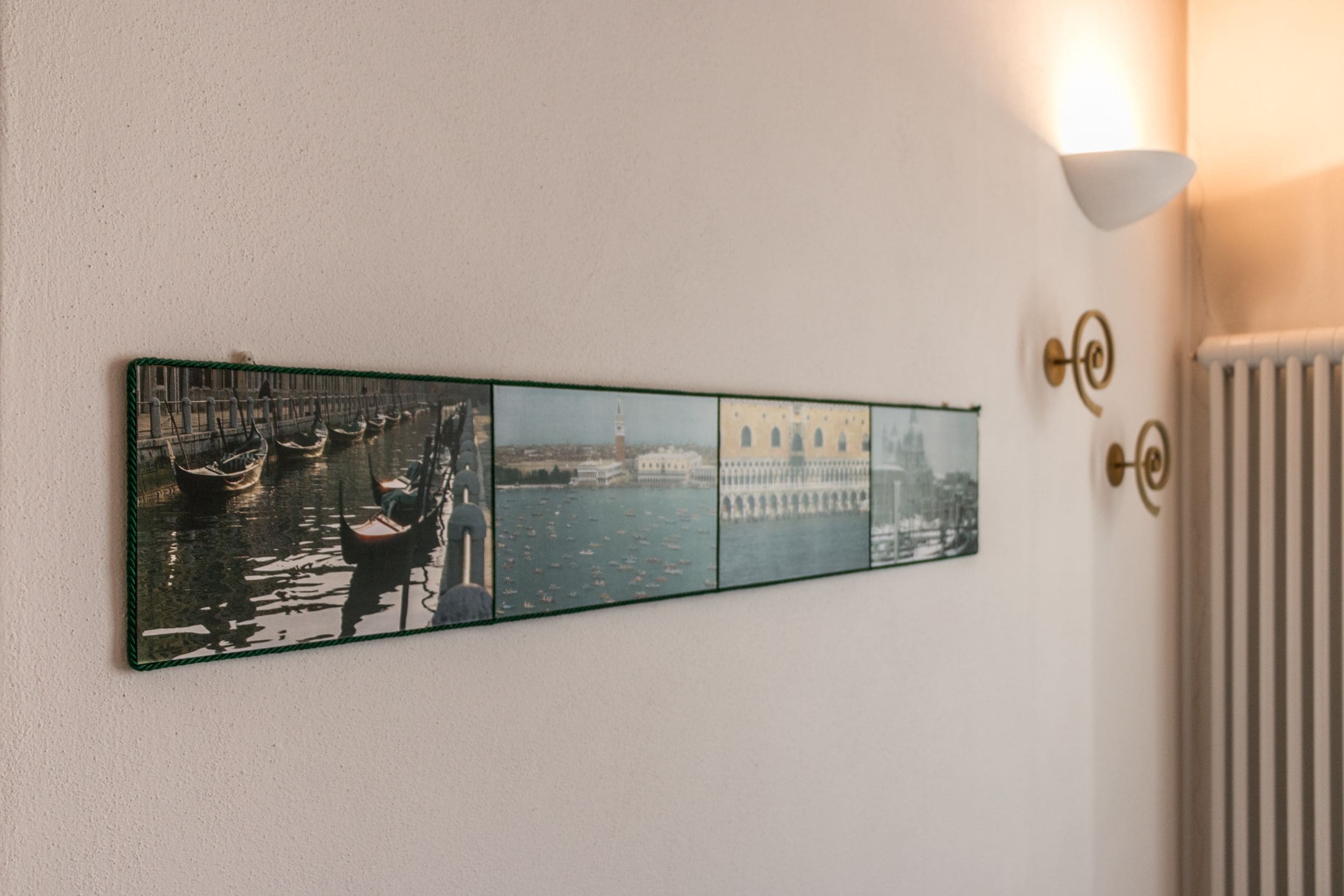 Eine Wanddekoration, die eine Szene mit einem Kanal, Booten und Gebäuden zeigt.