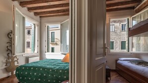 Un dormitorio con cama, banca y ventana.