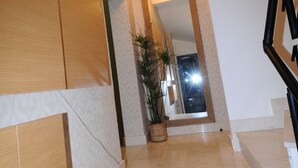 A modern interior with a staircase, a large mirror, and a decorative light fixture. - Cheya Gumussuyu Residence (Istanbul)