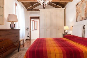 Un dormitorio con una cama grande, tocador de madera y una araña.