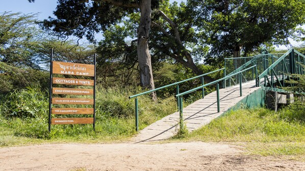 A sign listing amenities at Spreeinn Mara Camp including cottages, tents, a conference hall, a restaurant, a bar, and a swimming pool.