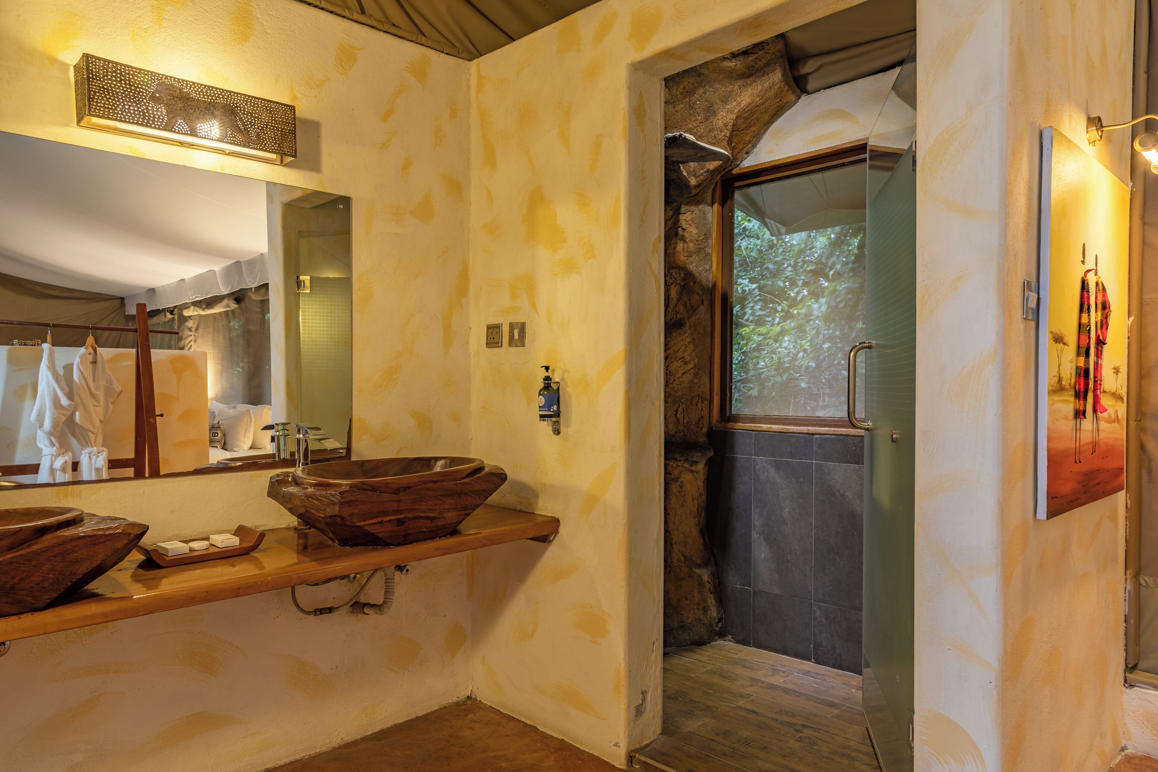 Een badkamer met een houten wastafelmeubel, een grote spiegel en een douchehoek.