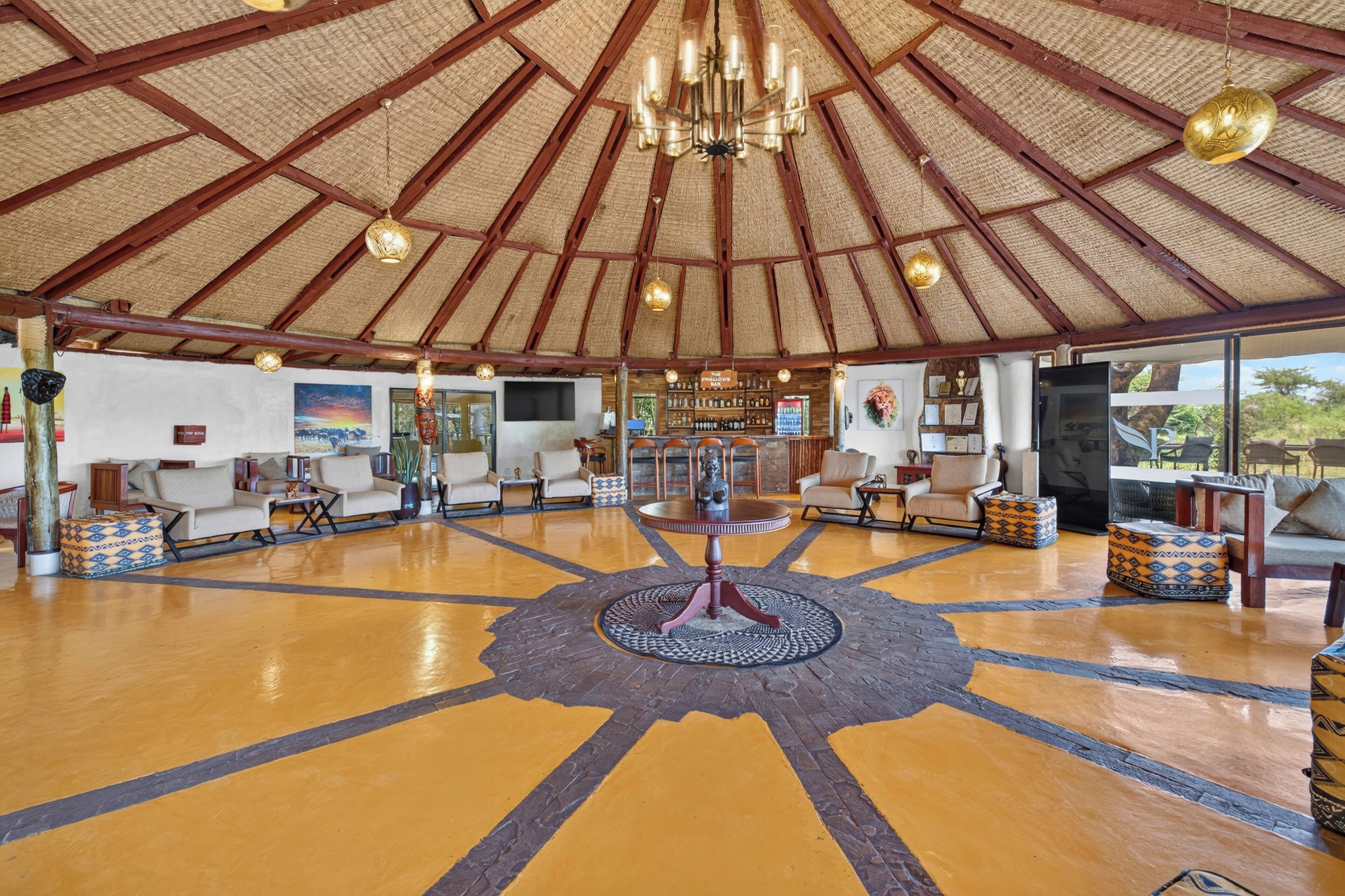 A spacious lobby with a high ceiling, a central chandelier, and a patterned floor.