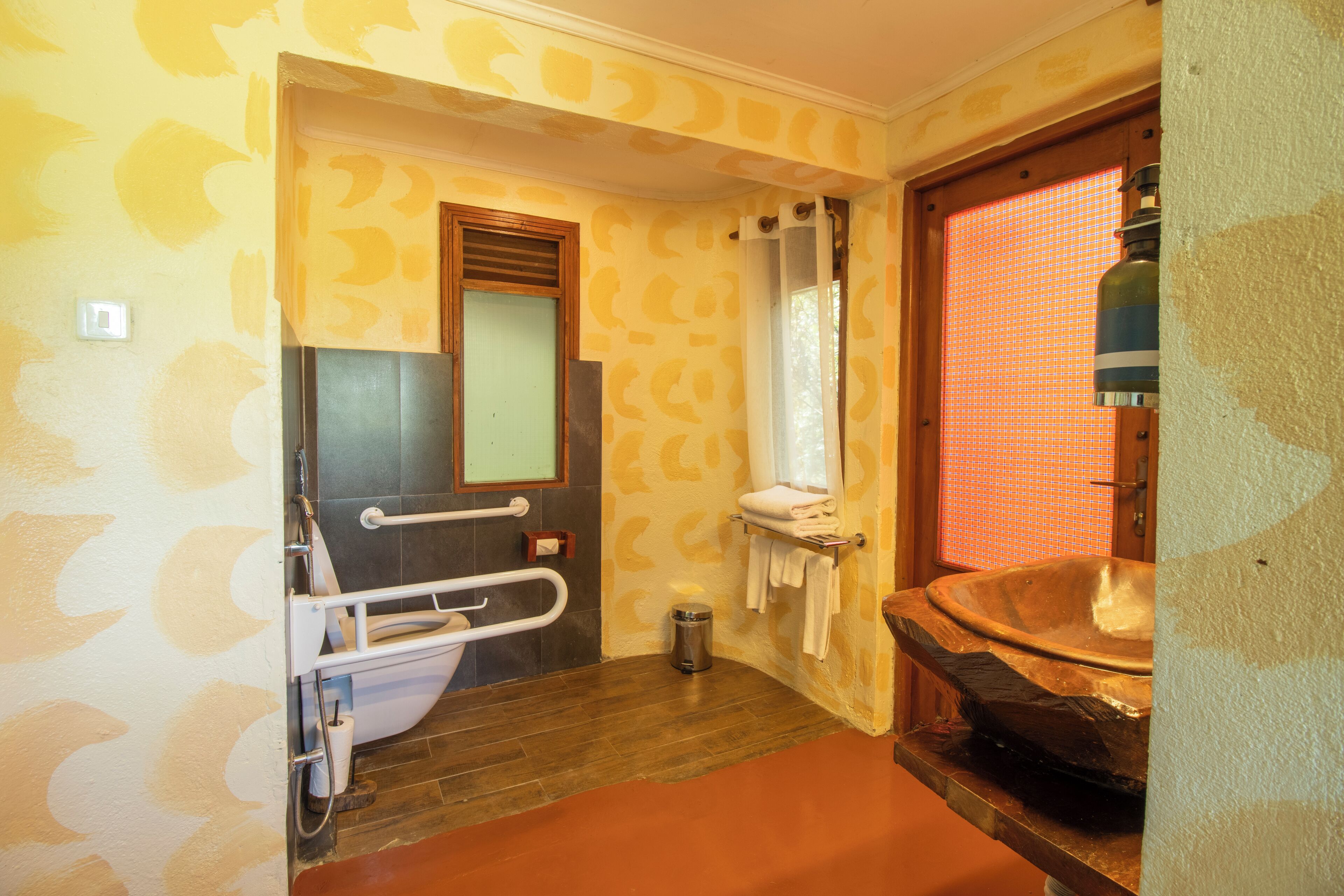Un baño con bañera de madera, un pasamanos, un espejo y una cortina de ducha.