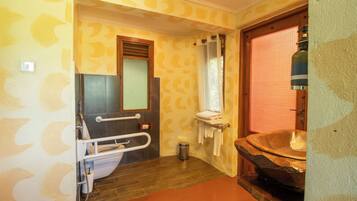 Un baño con bañera de madera, un pasamanos, un espejo y una cortina de ducha.