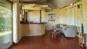 Une pièce comprenant un comptoir d’accueil incurvé, un canapé, une petite table ronde et un tableau représentant des animaux au mur.