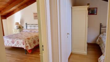 A bedroom with a bed, a nightstand, a wardrobe, and a wooden ceiling.