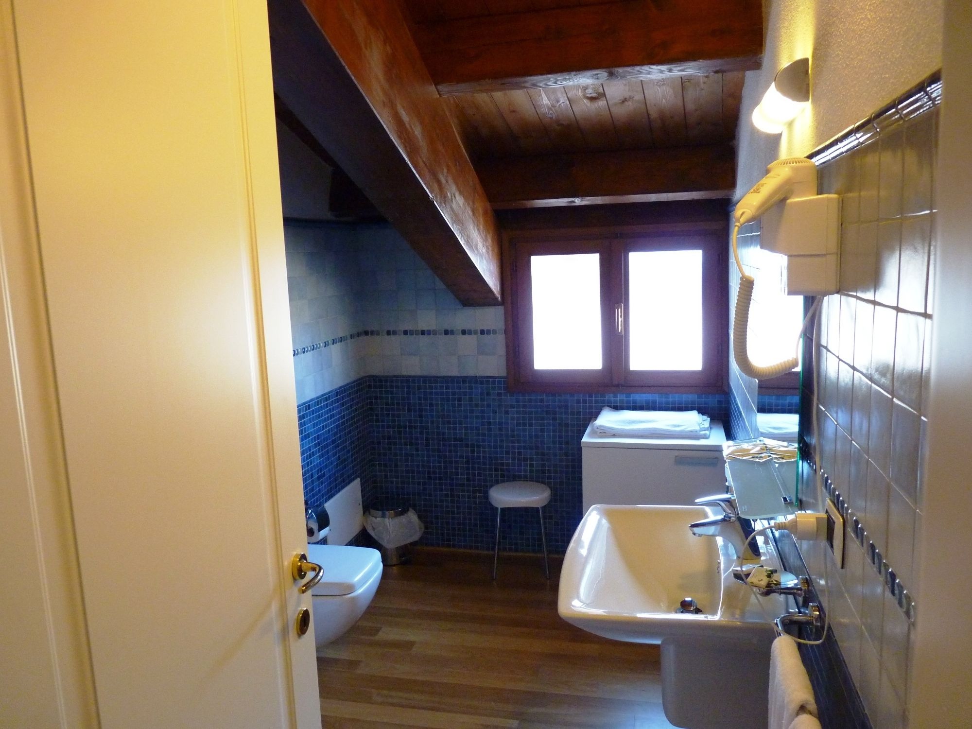 Un baño con inodoro, lavamanos y ventana.