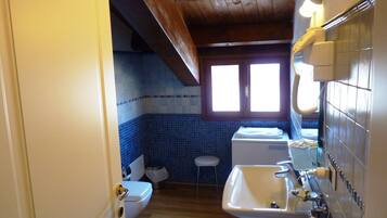 Un baño con inodoro, lavamanos y ventana.