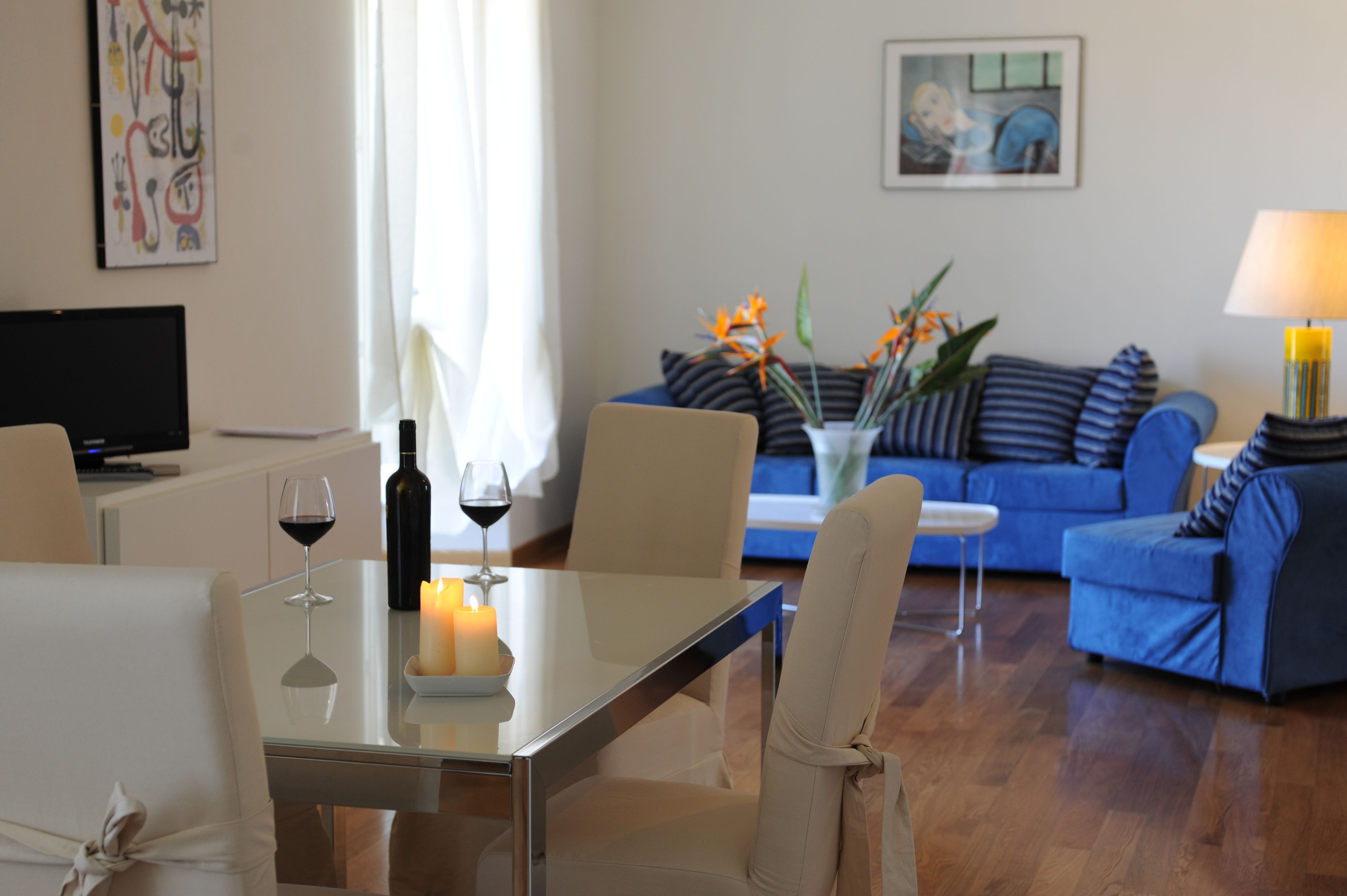 Ein modernes Wohnzimmer mit Esstisch, einer Couch und einem Fernseher.