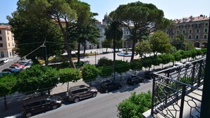 Une vue de rue avec des voitures garées, des arbres et des bâtiments.
