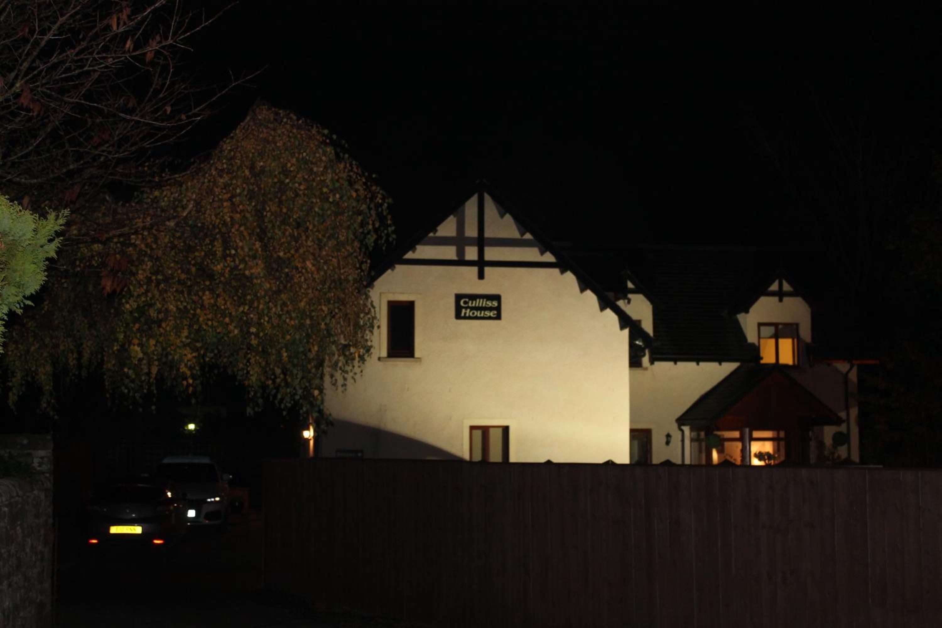 A building with a sign reading 'Cullis House' at night.