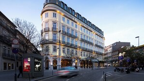 Een hotel met meerdere verdiepingen, in een klassieke Europese bouwstijl, met balkons en grote ramen.