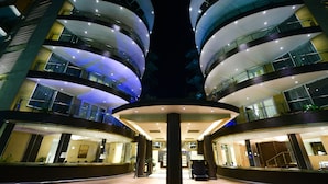 A modern hotel with multiple floors, large windows, and a central atrium. - Protea Hotel by Marriott Kampala Skyz (Kampala)