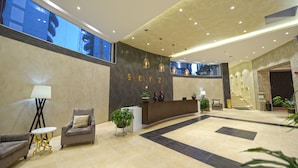 A modern hotel lobby with a reception desk, seating area, and a staircase. - Protea Hotel by Marriott Kampala Skyz (Kampala)