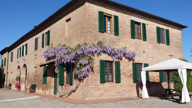 A historic building with green shutters and a covered patio area. - Agriturismo il Poggiarello (Siena)