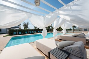 Een seizoensgebonden buitenzwembad en ligstoelen