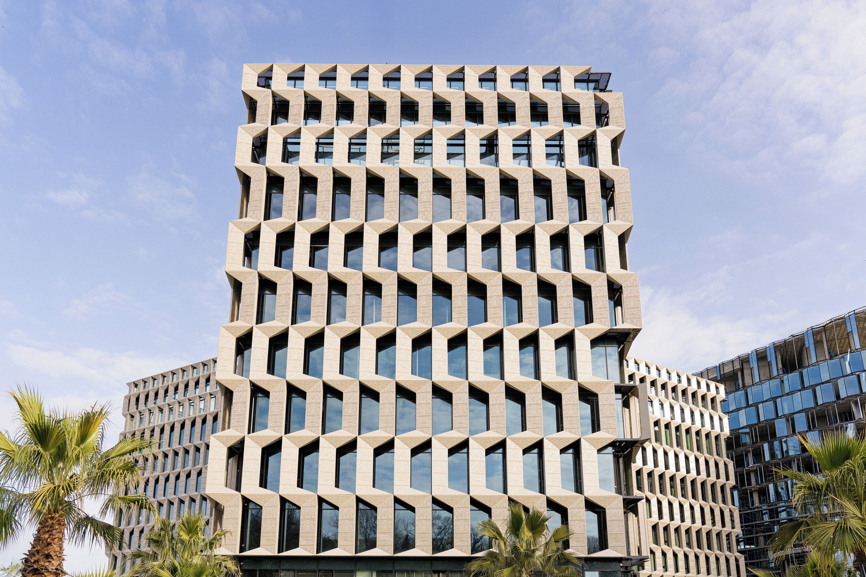 A modern building with a geometric facade, multiple floors, and large windows.