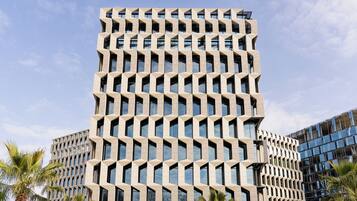 A modern building with a geometric facade, multiple floors, and large windows.