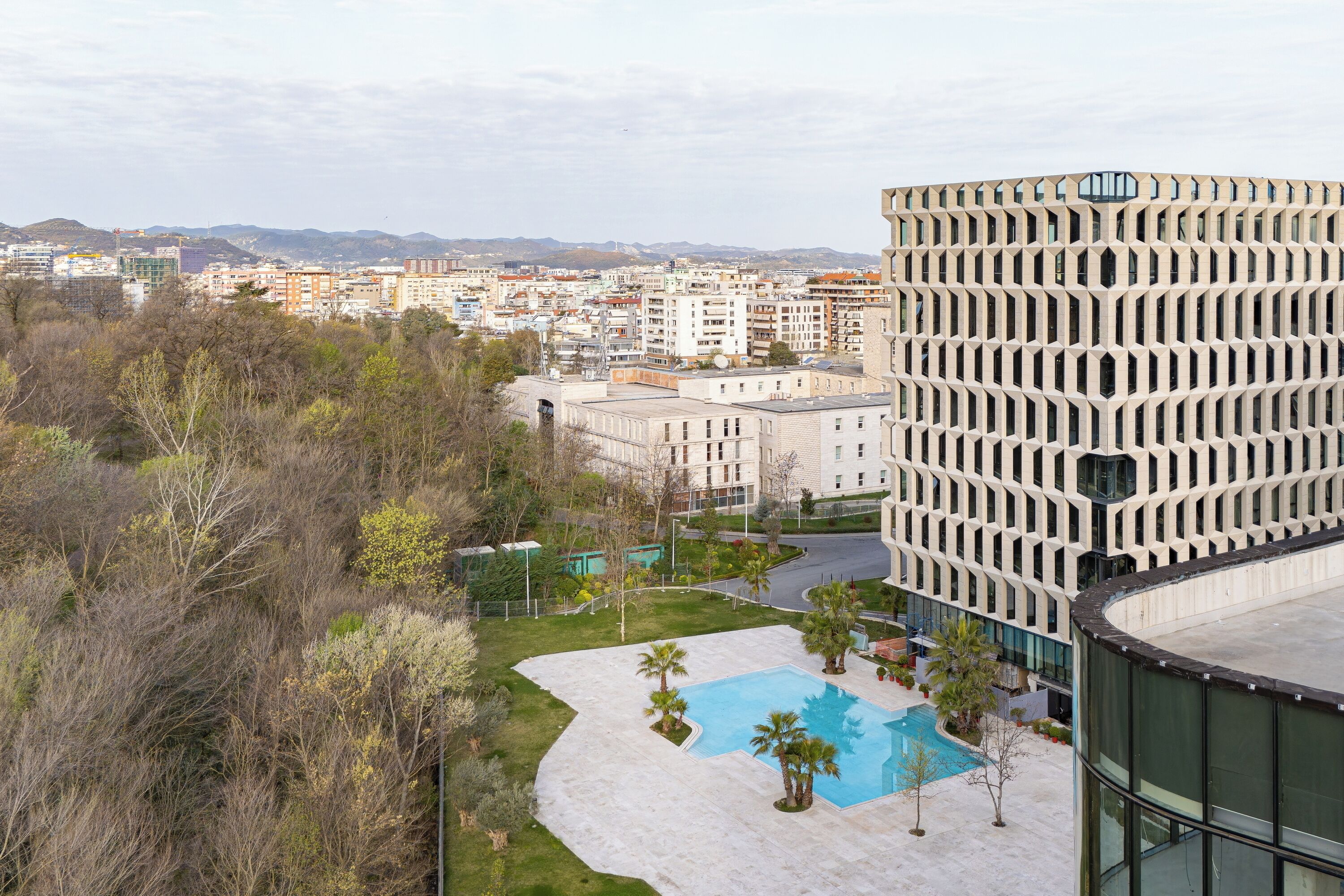 A modern building with a pool and landscaped area.