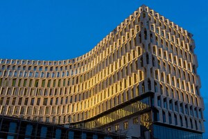 Un edificio moderno con una fachada geométrica distintiva y múltiples ventanas.