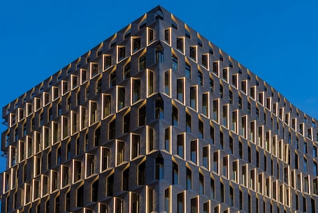 A modern building with a geometric facade and uniform window patterns.