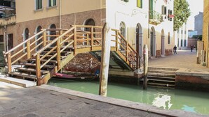 Un puente de madera sobre un canal con una barca amarrada al final.
