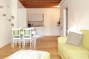 A compact living space with a dining area, a kitchen, and a sofa. - Mazzoni 15 Modern Flat (Venice)