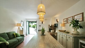 A modern kitchen with a wooden table, green sofa, and pendant lighting. - Agriturismo Casale Le Crete (Acquapendente)
