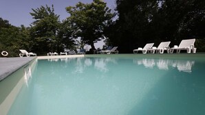 A swimming pool with white lounge chairs and a lifebuoy. - Agriturismo Casale Le Crete (Acquapendente)