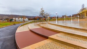 A park with a paved walkway, a gazebo, and a playground. - Chateau Qusar (Qusar)