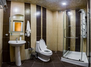 Une salle de bain moderne avec un lavabo, des toilettes et une douche à parois de verre.