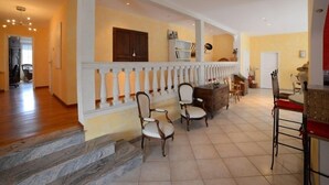 A spacious living area with a balcony, wooden flooring, and a staircase leading to another level. - Voirin Valérie (Cramant)