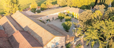 Un patio con edificios, un área pavimentada y árboles.
