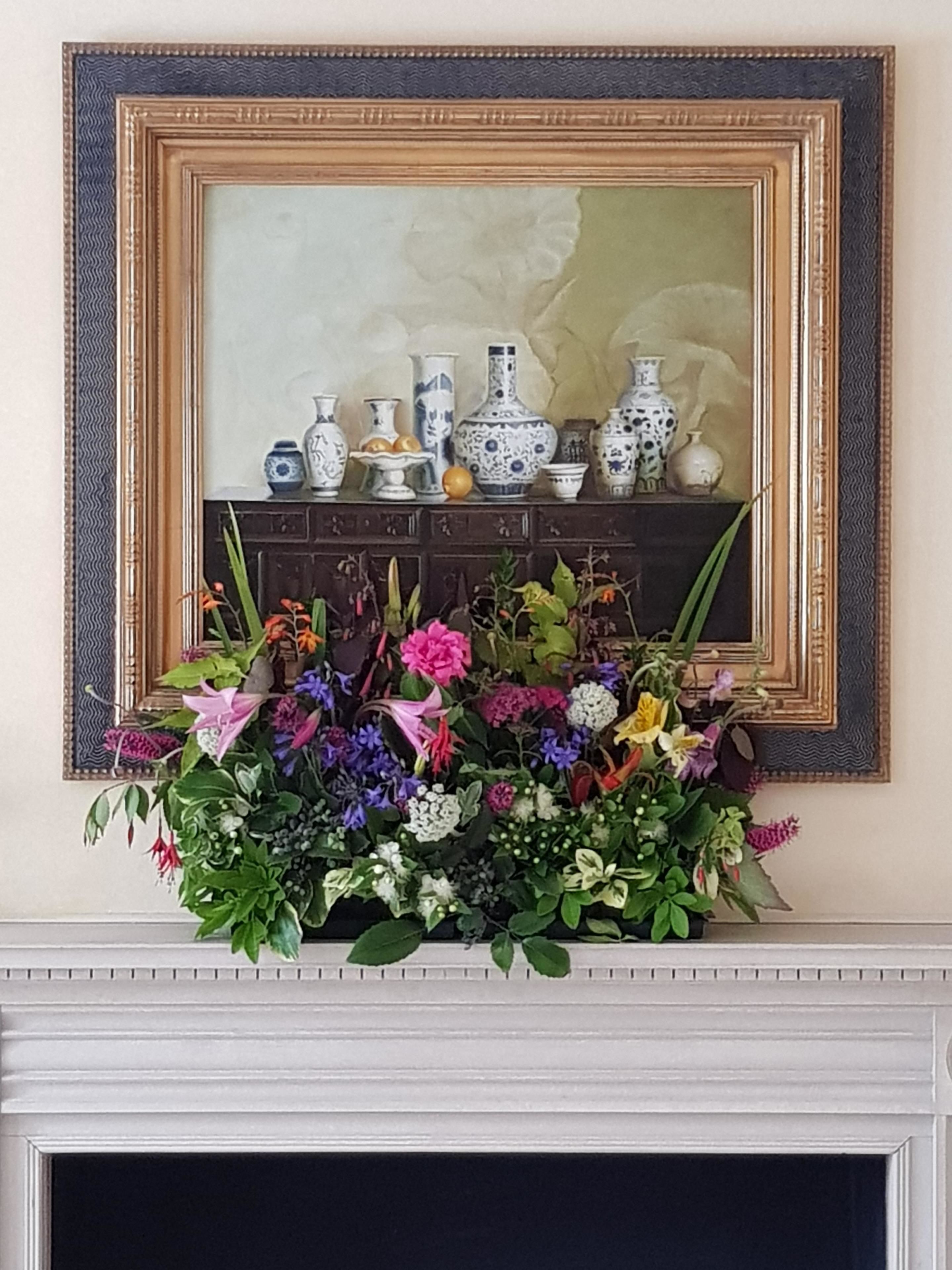 Uma lareira com uma coroa de flores e uma coleção de vasos de cerâmica.