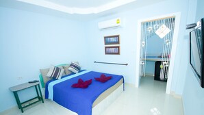 Un dormitorio con una cama, una mesita, un espejo y un equipo de aire acondicionado.