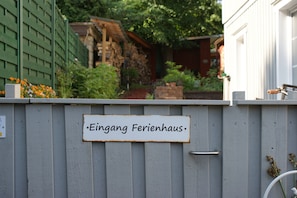 Een bordje op een grijze schutting met de tekst 'Eingang Ferienhaus'.