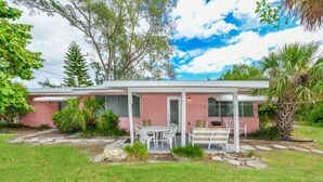 A single-story house with a covered patio area, a small garden, and a lawn. - The Seashell. Private Home #54561 3 Bedrooms 2 Bathrooms Home (Holmes Beach)