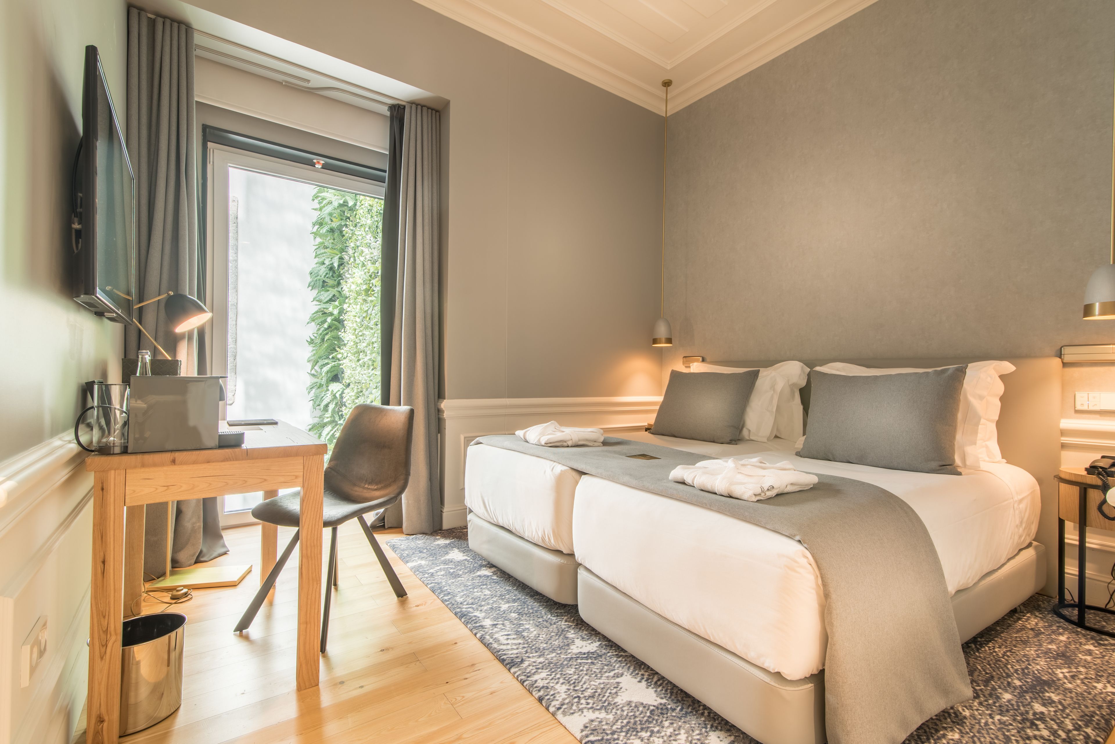 A modern bedroom with a large bed, a desk, and a chair.