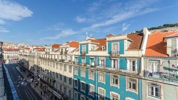 A row of multi-story buildings with balconies and a clear sky.