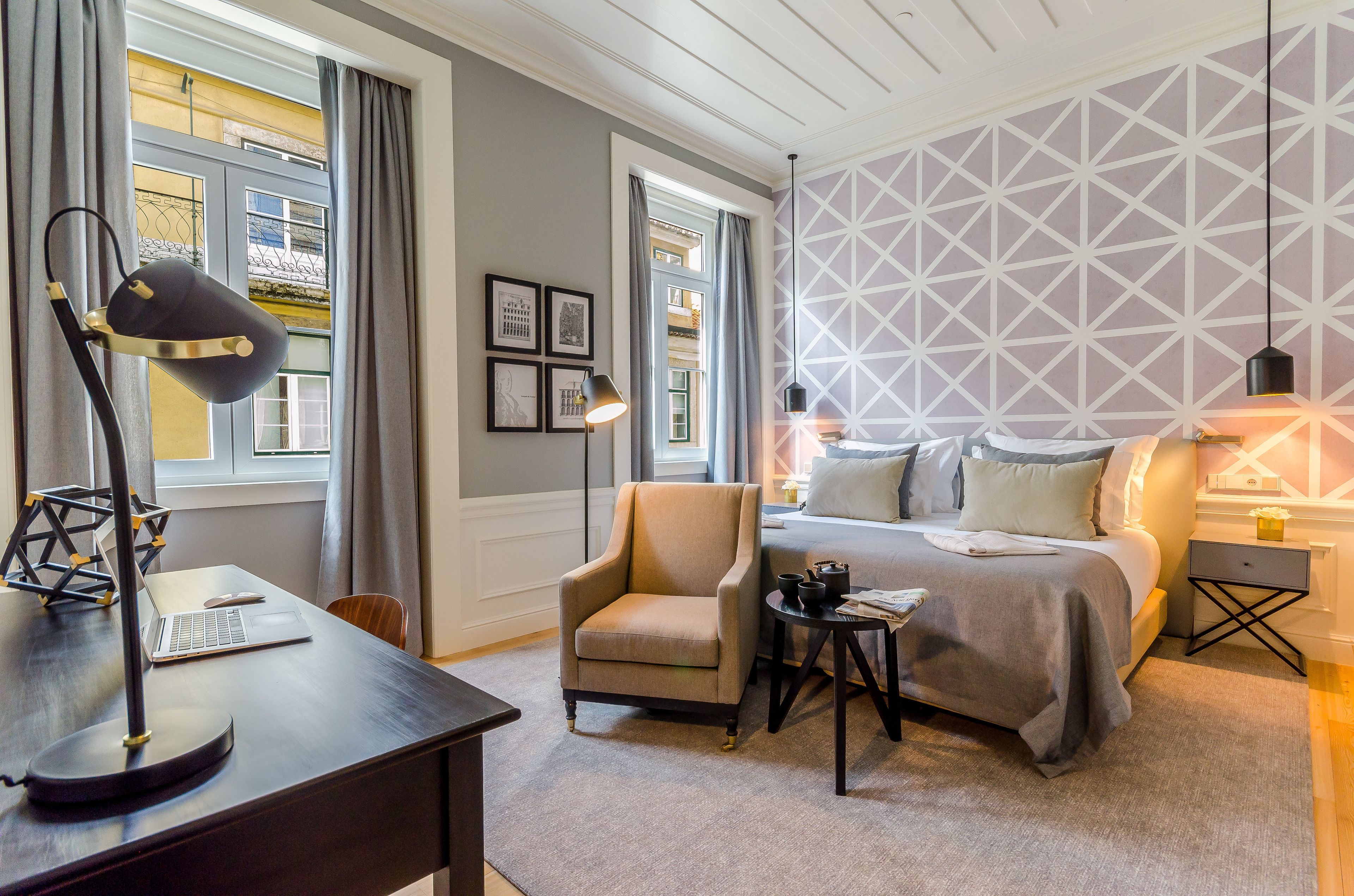 A bedroom with a bed, a desk, a chair, and a nightstand.