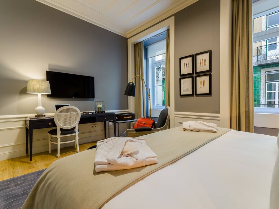 Een hotelkamer met een bed, bureau, stoel en een televisie.