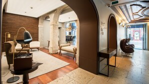 Ein modernes Interieur mit einer Holzwand, einem runden Tisch mit einer Lampe und einer Sitzecke mit Sofa und Sesseln.