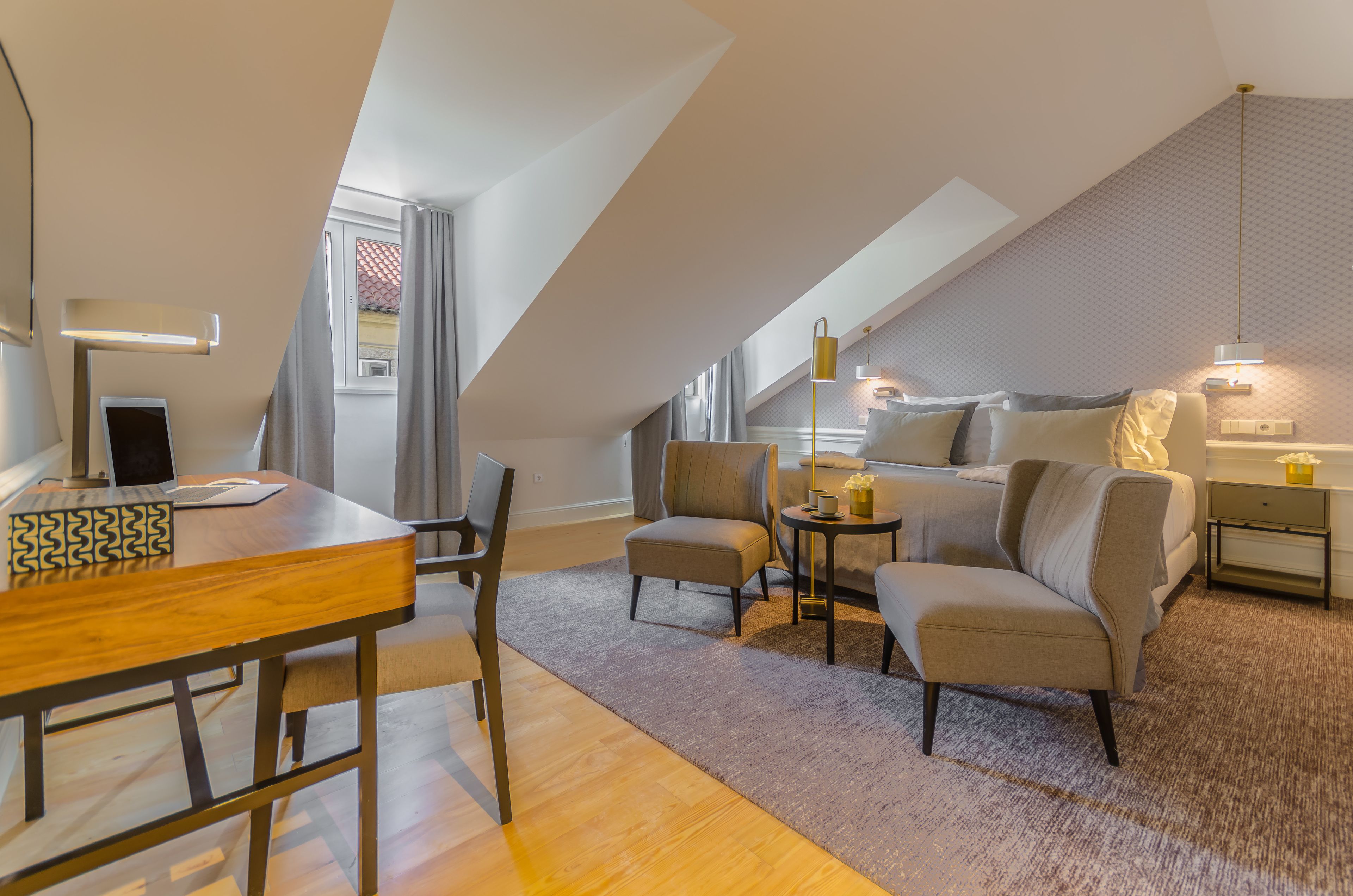 A modern loft-style room with a dining area, seating, and a bed.