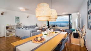 A modern living room with a dining area, a sofa set, and a view of the sea. - Sun Spalato Views (Split)