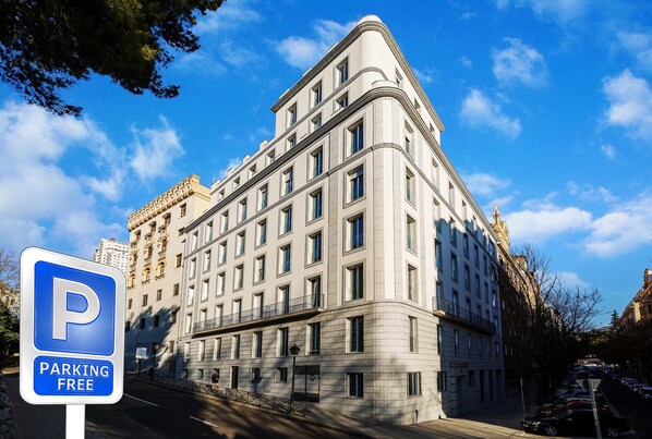 Un edificio de varios pisos con un letrero que indica estacionamiento gratuito.