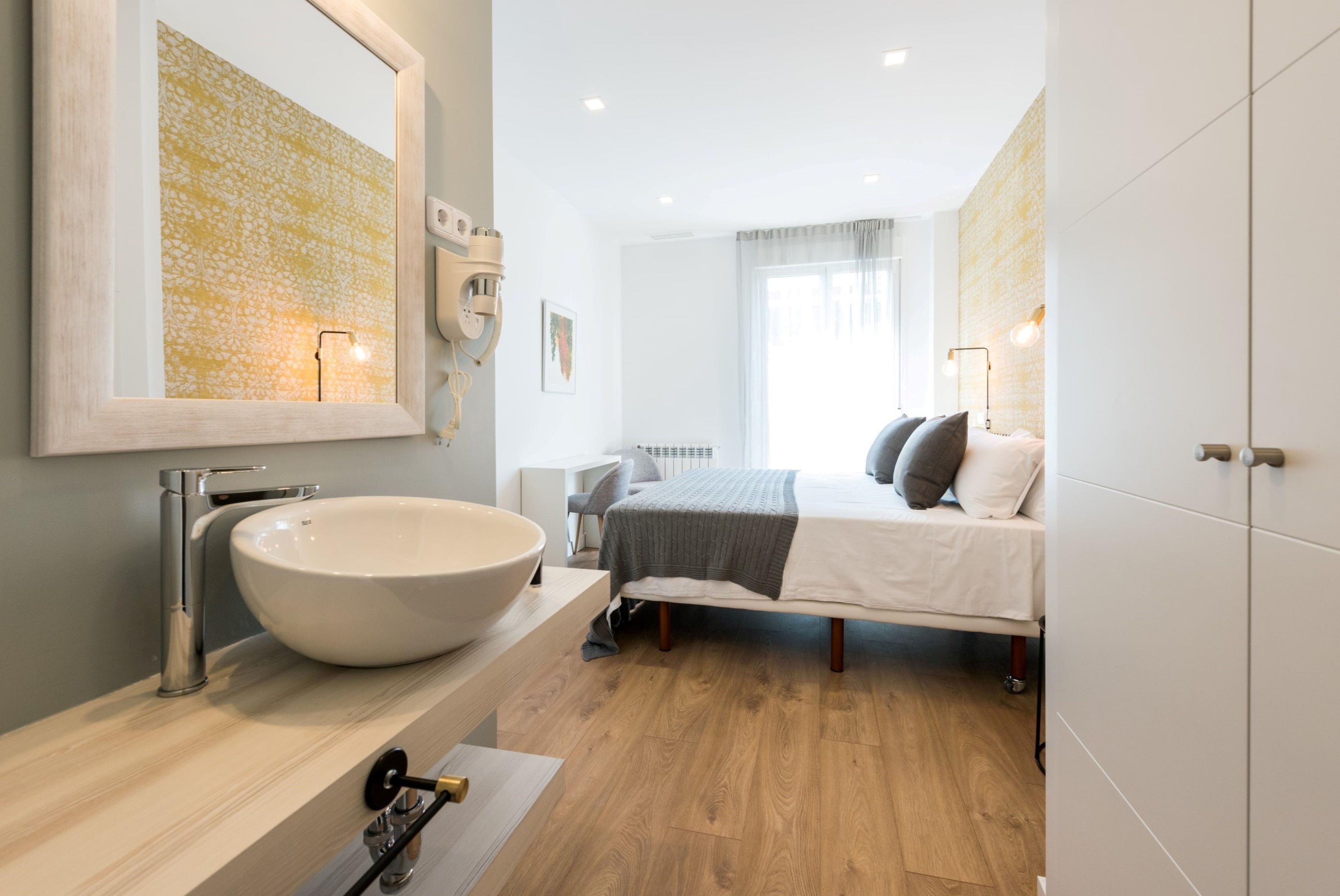 Une salle de bain moderne avec un grand lavabo blanc, un miroir et un meuble-lavabo en bois.