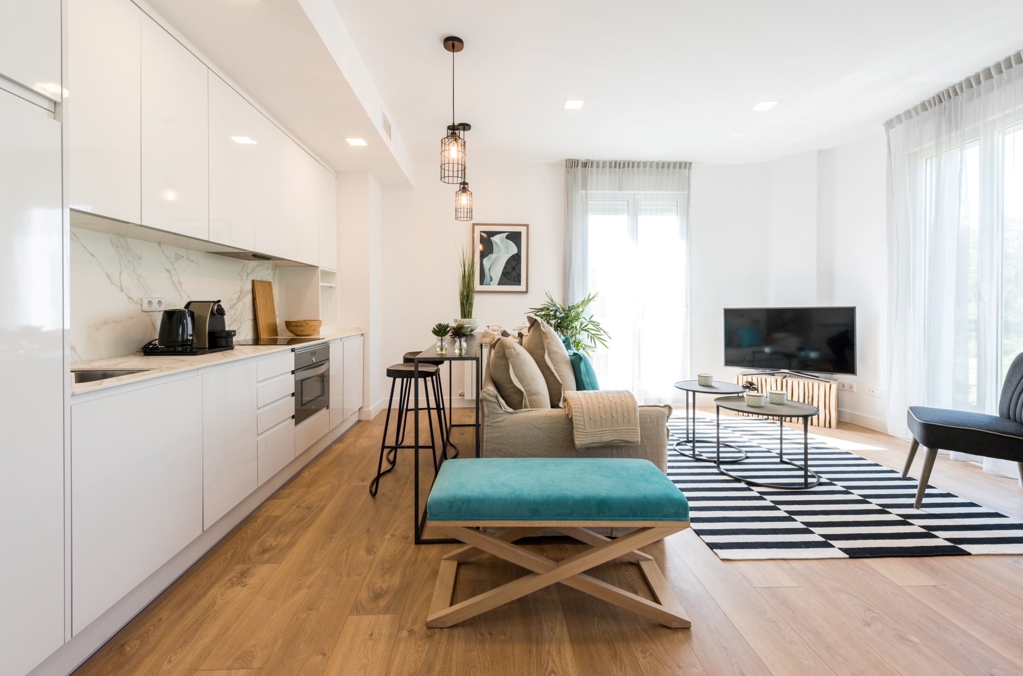 Un apartamento moderno con cocina, sala de estar y televisor.