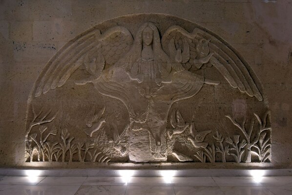 A stone relief sculpture of an angel with wings and a halo, set against a wall. - Alp Hotel Cappadocia (Avanos)