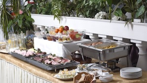 A buffet setup with various food items and condiments. - LAT Hotel & Apartmenthaus Berlin (Eisenhuettenstadt)